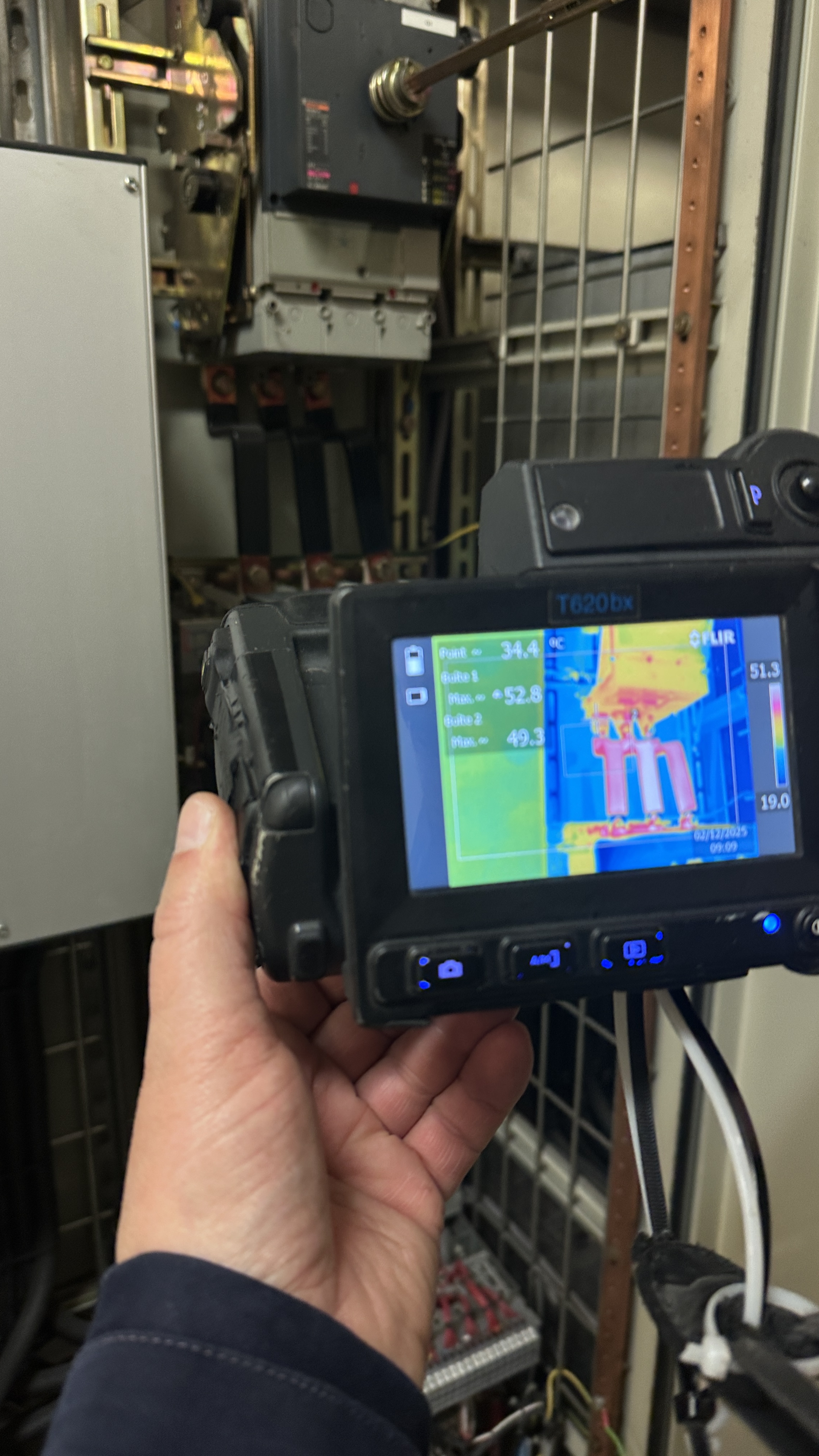 Écran de caméra thermique FLIR montrant un échauffement anormal à 52°C sur un disjoncteur lors d'un contrôle Q19
